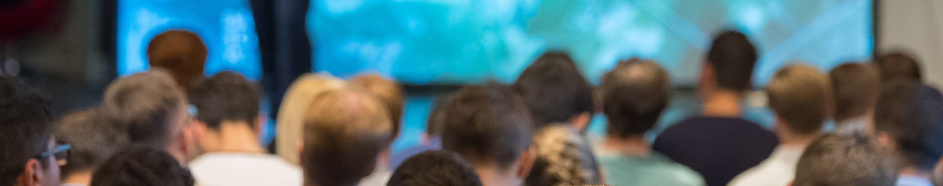 Image of audience of people listening to a presentation