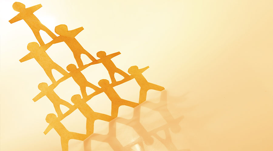 Image of cutout shapes of people standing on each others shoulders